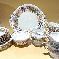 Group shot showing cake plate, serving bowl, creamer, cups and stacked plates