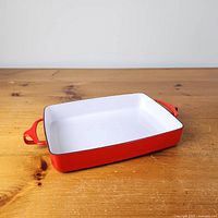 Overall view of red enamel Dansk Kobenstyle baking pan showing white interior and one handle