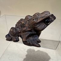 three-quarter view of carved cedar frog showing overall form and surface details