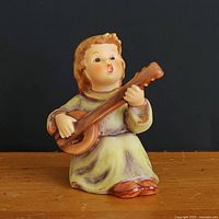 Front view of cherub figurine holding mandolin