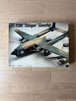 Front of model kit box showing painted AC-119K Stinger Gunship model artwork with Italeri branding and box measurements.
