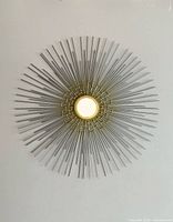 Full front view of metal sunburst mirror on wall
