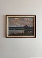 Full view of the framed landscape painting hung on a wall, showing the overall composition and condition.