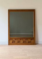 Full frontal view of mirror against wall showing entire frame and glass.