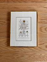 Framed black and white architectural and celestial art print photo from a top view on wood flooring.