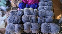 Grey skeins and assorted coloured balls of yarn