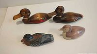 Four carved and painted wood duck figurines grouped