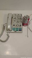 Full view of TEL-MAX big button corded phone beside soda can for scale