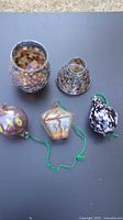 Five items laid out: two mosaic candle holders and three hanging glass ornaments.