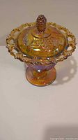 Full view of covered candy dish showing iridescent finish and openwork handles