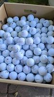 Top view of box filled with white golf balls