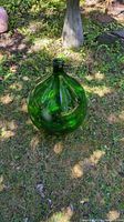 Full view of demijohn standing on grass