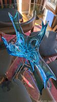 overview of blue freeform 4-arm glass sculpture on table