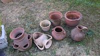 Group shot of seven terracotta pots on grass