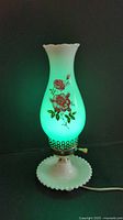 Lamp lit showing green glow through shade with rose decal