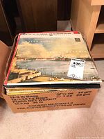 Stack of vinyl LP records in a cardboard box with 'Cooked Meatballs' printed on it, showing visible album cover on top for Handel Water Music