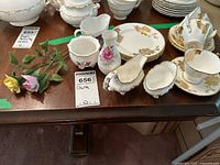 Full view of various china pieces on the table along with porcelain roses.