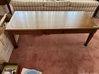 Wood coffee table showing full top surface, detailing, and legs.