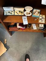 Top shelf wooden display with three jewelry boxes and multiple items