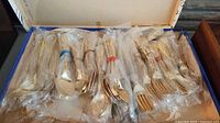 Box open showing multiple wrapped flatware bundles
