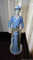 Front view of the Lladro yachtsman figurine showing the full figure and ship's wheel.