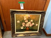 Front view of the vintage floral oil painting in a gilt frame showing the full artwork and frame details.