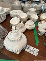 Teapot with lid, sugar bowl, creamer and front row of tea cups