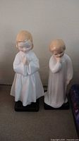 Front view of two Royal Doulton china figurines placed side by side on a flat surface.