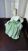 Front view of Royal Doulton Fair Lady figurine in green dress with blue handbag