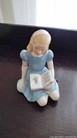 Front view of the Royal Doulton figurine showing the girl reading the book.