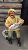 Front view of Royal Doulton figurine The Boatman, holding fish and life preserver ring
