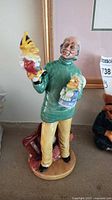 Front view of the Royal Doulton Punch and Judy Man figurine showing the figure holding two puppets with detailed painting and glazed finish.