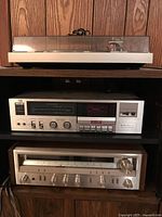 Front view of turntable stacked above cassette deck and receiver