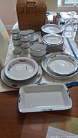 Overview of the entire 42-piece Dansk dishware set including stacked plates, cups, and serving tray with floral pattern.