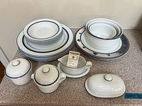 Full set of Dansk serving dishes including platters, bowls, covered butter dish, cream and sugar containers, and gravy boat.
