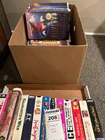 Box of VHS tapes including Disney titles Fantasia, Charlotte's Web, and E.T.