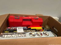 Top view of cardboard box containing various Lego sets including Star Wars, Bionicle, and Lego branded red plastic carrying case