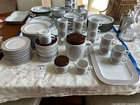Overall set of plates, cups, saucers, creamer and sugar bowl on table