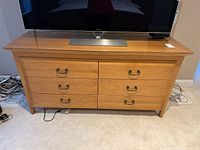 Front view of the six drawer dresser with a TV on top showing overall condition and appearance.