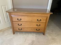 Front elevation of the three-drawer dresser showing overall condition and plastic top protector.