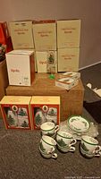 Multiple boxed sets of Spode Christmas Tree Christmas themed glassware and cups visible in storage boxes.