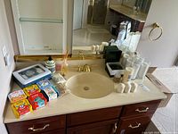 Photo of bathroom countertop with Welly Bravery Bandages, candles, Crabtree & Evelyn sachets, and other items displayed.