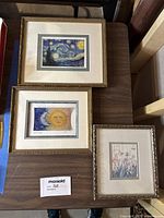 Three framed art prints arranged on a table: Starry Night, Night & Day, and Flowers