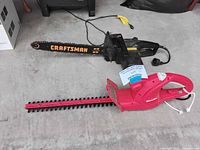Craftsman corded chainsaw with 16-inch bar and Homesite corded hedge trimmer visible on concrete floor.
