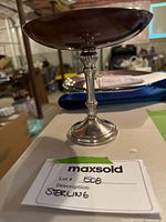 Side view of sterling silver candy dish displaying the weighted sterling mark on the polished silver base and wooden dish top.