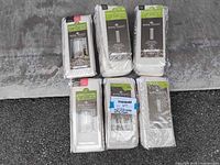 Six packages of Royal Velvet window drapes with energy-saving labels, arranged on a surface