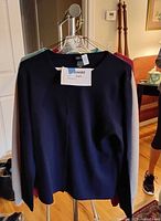 Dark blue crew neck cashmere sweater displayed on hanger