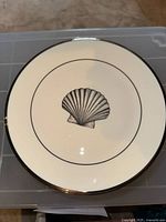 Close-up image of the plate showing the seashell design and silver lining on the front.