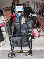 Front view of black collapsible utility roller cart with handle and mesh pocket