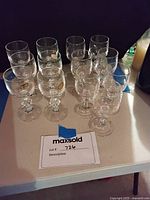 Image showing a total of 13 glasses arranged on a table: 4 vintage crystal glasses, 7 wine goblets, and 2 glass goblets.